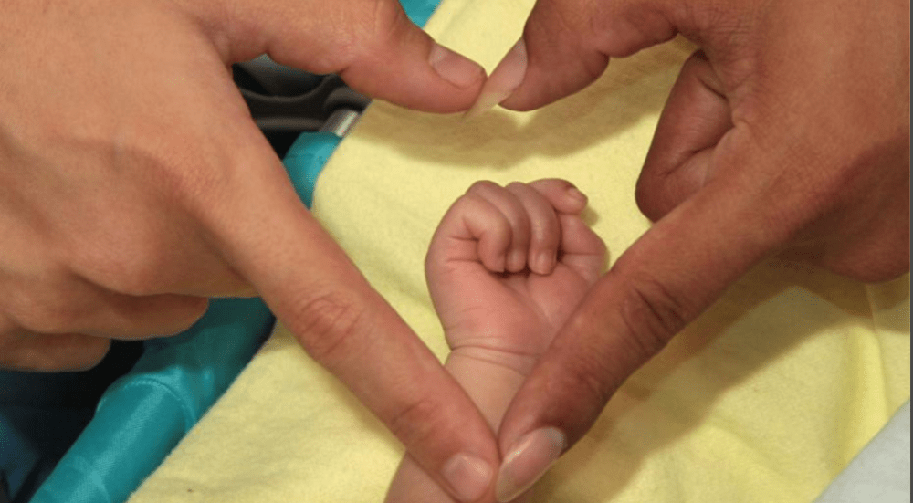 Activistas transexuales Diane Rodriguez y Fernando Machado se convirtieron en padres forman un corazon con la mano de ellos